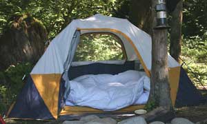 image of down comforter, pillows and featherbed in a tent